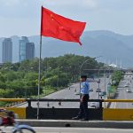 A policeman stands guard under the national flags of China and Pakistan along a road ahead of the visit of Chinese Vice Premier He Lifeng, in Islamabad on July 30, 2023. He was due in the Pakistan capital on July 30 to mark the 10th anniversary of a mega economic plan that is the cornerstone of Beijing's Belt and Road Initiative. (Photo by Farooq NAEEM / AFP) (Photo by FAROOQ NAEEM/AFP via Getty Images)