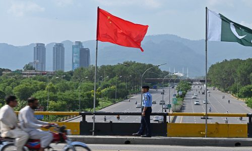 A policeman stands guard under the national flags of China and Pakistan along a road ahead of the visit of Chinese Vice Premier He Lifeng, in Islamabad on July 30, 2023. He was due in the Pakistan capital on July 30 to mark the 10th anniversary of a mega economic plan that is the cornerstone of Beijing's Belt and Road Initiative. (Photo by Farooq NAEEM / AFP) (Photo by FAROOQ NAEEM/AFP via Getty Images)